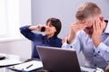 Businessman Getting Irritated With Colleague Talking On Phone