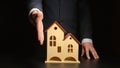 Businessman give handshake over a house model on a table