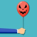 A businessman gives a balloon a Halloween ghost face. Deceptive concept