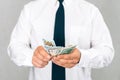 Businessman gives money in a white shirt with a tie. On a light background