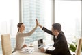 Businessman giving businesswoman high five at office, city side