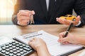 Businessman giving car key and customer signing loan agreement w