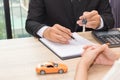 Businessman giving car key and explain about loan agreement with Royalty Free Stock Photo