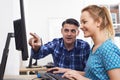 Businessman Giving Computer Training To Female Trainee In Offic
