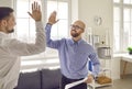 Businessman giving high five to his partner at meeting in office Royalty Free Stock Photo