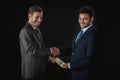 Businessman giving money and bribing business partner isolated on black