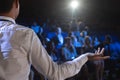 Businessman giving presentation in front of audience in auditorium Royalty Free Stock Photo