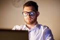 Businessman in glasses with laptop at night office