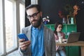 Businessman in glasses with smartphone over woman working on bac