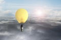 Businessman in glowing yellow lightbulb hot air balloon flying