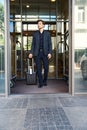 Businessman going outside hotel with suitcase in hand Royalty Free Stock Photo