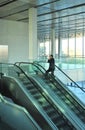 Businessman going up an escalator, conference center, business meeting