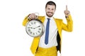 Businessman in a gold suit holding a clock in his hands