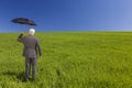 Businessman In A Green Field With An Umbrella Royalty Free Stock Photo