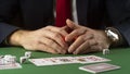 Businessman at green gaming table with game chips, cards and dice playing poker and blackjack in casino Royalty Free Stock Photo