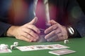 Businessman at green gaming table with game chips, cards and dice playing poker and blackjack in casino Royalty Free Stock Photo