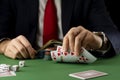 Businessman at green gaming table with game chips, cards and dice playing poker and blackjack in casino Royalty Free Stock Photo