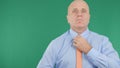 Businessman With Green Screen in Background Arranging His Tie.