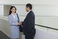 Businessman Greeting Female Colleague In Office