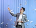 Businessman in Grey Suit Holding Gold Coins with Falling Dollar Royalty Free Stock Photo