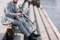 businessman in grey suit reading newspaper on stairs on quay with bicycle Royalty Free Stock Photo