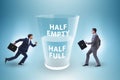 Businessman in half empty half full glass concept Royalty Free Stock Photo