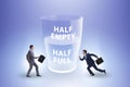 Businessman in half empty half full glass concept Royalty Free Stock Photo