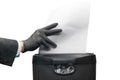 Businessman hand in a black latex glove shredding documents in a shredder Royalty Free Stock Photo