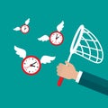 Businessman hand with butterfly net catches flying clock with wings