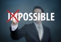 Businessman hand Changing the word `impossible to possible` with red marker on transparent board