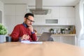 Businessman with hand on chin thinking ideas and writing on notepad while using laptop on desk Royalty Free Stock Photo