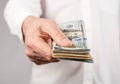 Businessman hand closeup holding US dollars stack. Finance and tax concept. Man receiving or paying salary, debt