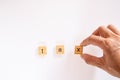 Businessman hand creates the word `tax` of the wooden letter blocks on white background. Royalty Free Stock Photo