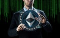 Businessman hand with ethereum over binary code