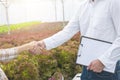 Businessman hand hold contract and asian woman farmer success deal contract in greenhouse hydroponic organic farm ,Small business Royalty Free Stock Photo