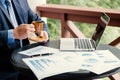 Businessman hand holding coffee cup, analysis the graph with laptop at the home office for setting challenging business goals And Royalty Free Stock Photo