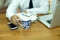 Businessman hand holding coffee mug with cell phone and notebook Royalty Free Stock Photo