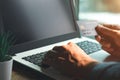 Businessman hand holding credit card with using laptop for online shopping while making orders at home. Royalty Free Stock Photo