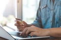 Businessman hand holding credit card with using laptop for online shopping while making orders at home. business Royalty Free Stock Photo