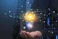 Businessman hand holding digital hologram of colorful light bulb as a concept of new idea for start up. Concept of creativity and Royalty Free Stock Photo