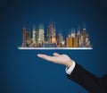 Businessman hand holding digital tablet with modern buildings hologram. Smart city, building technology and real estate business Royalty Free Stock Photo