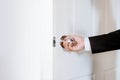 Businessman hand holding door knob, opening or closing door, with bright behind the door Royalty Free Stock Photo