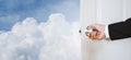 Businessman hand holding door knob, opening to the sky and clouds, with copy space, abstract business concept with copy space