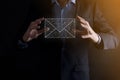 Businessman hand holding e-mail icon  Contact us by newsletter email and protect your personal information from spam mail. Royalty Free Stock Photo