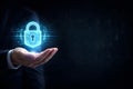 Businessman hand holding futuristic glowing blue padlock hologram on dark digital binary code background. Royalty Free Stock Photo