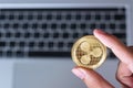 Businessman hand holding golden Ripple XRP cryptocurrency coin over keyboard laptop, Ripple coin. Crypto is Digital Money within Royalty Free Stock Photo