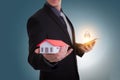 Businessman hand holding house representing home ownership and t Royalty Free Stock Photo