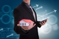 Businessman hand holding house representing home ownership and t Royalty Free Stock Photo