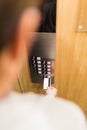 Close up of man holding cardkey on control panel elevator access concept