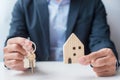 Businessman hand holding key with wooden Home model. Real estate, buy and sale, Property insurance, rental and contract agreement Royalty Free Stock Photo